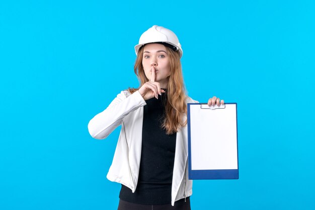 Front view young female architect holding file note on blue