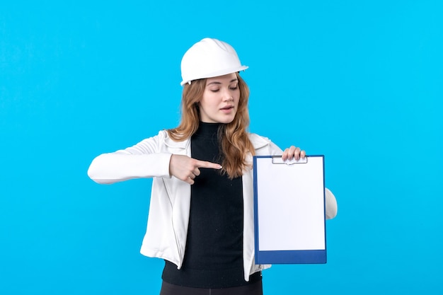 Front view young female architect holding file note on the blue