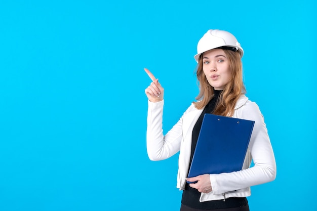 Free photo front view young female architect in white helmet on blue