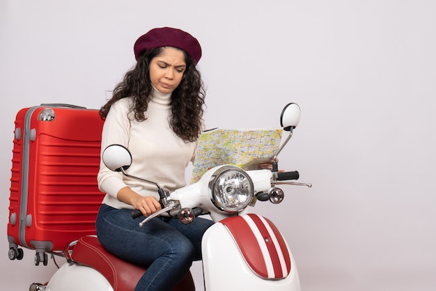 白い背景の都市の色の道路の休暇車のオートバイの乗車速度の地図を観察する自転車の正面の若い女性