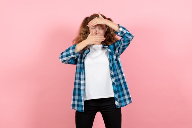 Вид спереди молодая женщина в синей клетчатой рубашке позирует на розовом фоне парень девушка молодежь эмоция модель мода