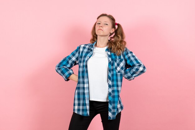 Front view young female in blue checkered shirt posing on a pink background youth emotion girl kid model fashion