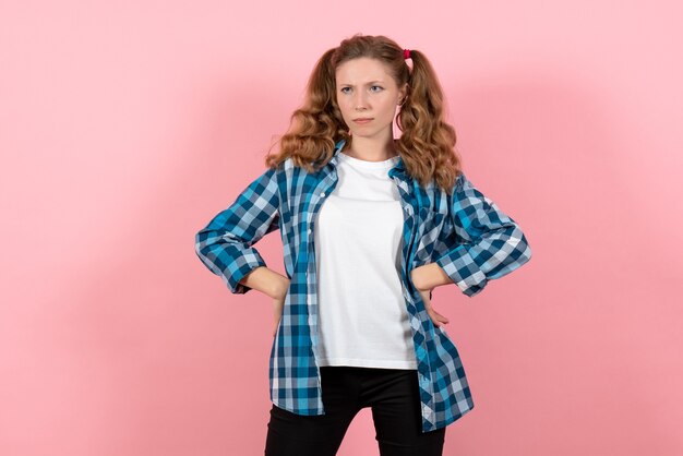 Front view young female in blue checkered shirt posing on a pink background youth emotions girl model kid fashion