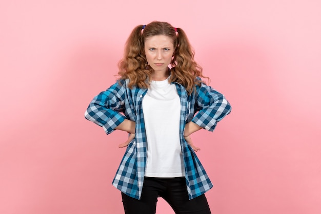 Front view young female in blue checkered shirt posing with mad expression on pink background woman emotions model fashion girls color