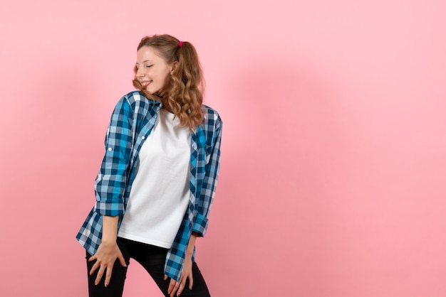 Free photo front view young female in blue checkered shirt posing with smile on a pink background woman emotions girls fashion color model