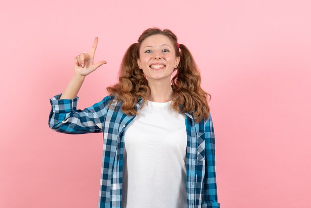 Front view young female in blue checkered shirt smiling and posing on pink background woman emotions model fashion girls color