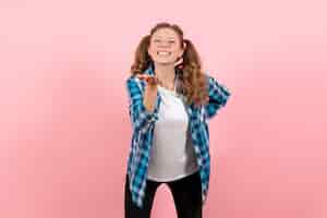 Foto gratuita vista frontale giovane femmina in camicia a scacchi blu con felice espressione su sfondo rosa emozione giovanile ragazza ragazzino moda modello