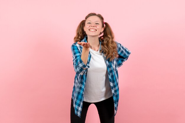ピンクの背景に幸せな表情と青い市松模様のシャツの正面図若い女性若者の感情女の子子供モデルファッション
