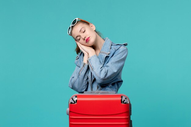 Front view young female in blue jacket getting ready for trip and feeling tired on blue space