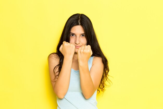 A front view young female in blue shirt posing showing her fists