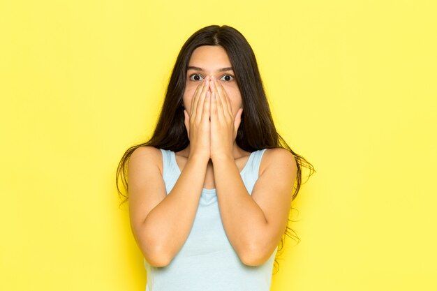 A front view young female in blue shirt posing with shocked expression