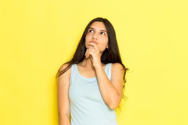 A front view young female in blue shirt posing with thinking expression