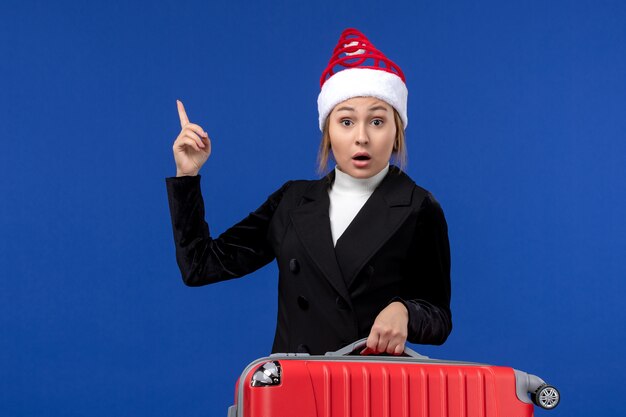 Front view young female carrying red bag on a blue desk vacation trip woman holiday