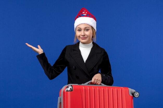 파란색 벽 여행 휴가 휴가 여자에 빨간 가방을 들고 전면보기 젊은 여성