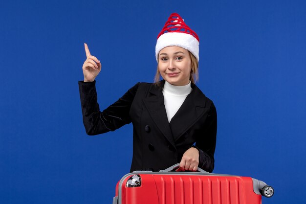 Front view young female carrying red bag on blue wall vacation trip woman holidays