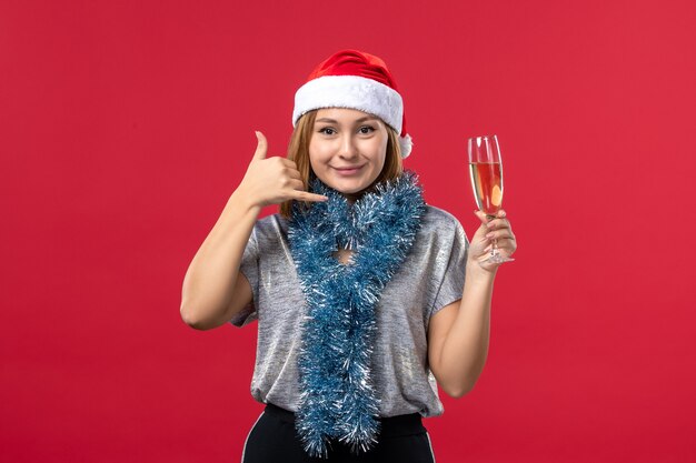 Front view young female celebrating new year on red wall christmas party holiday