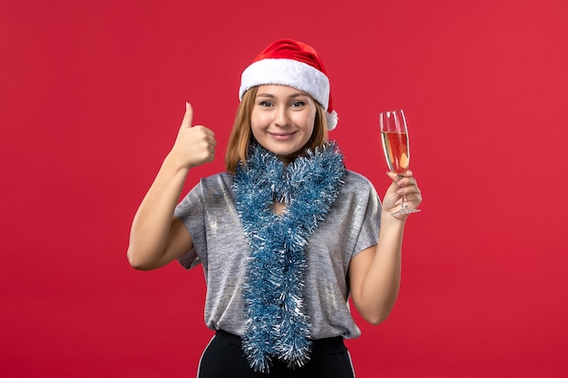 Front view young female celebrating new year on red wall christmas party holidays