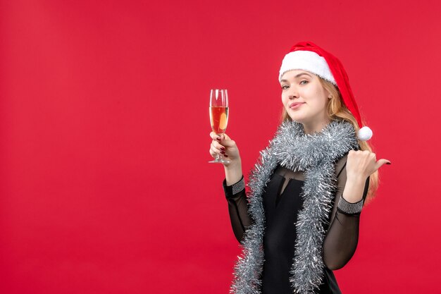 赤い壁の休日の感情のクリスマスに新年を祝う正面図若い女性