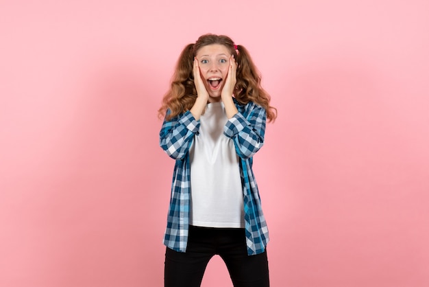 Front view young female in checkered shirt posing and feeling excited on pink background woman youth color emotions kid model