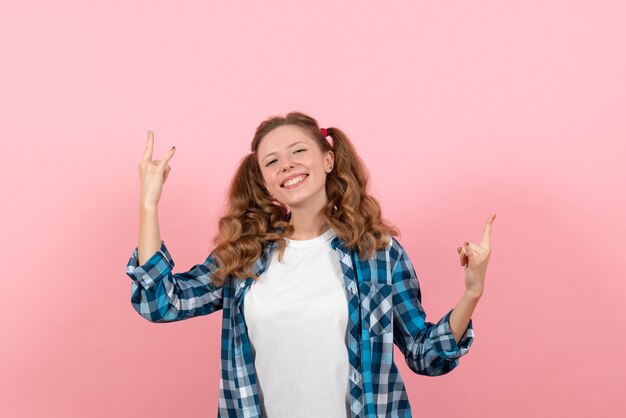 밝은 분홍색 배경에 포즈 체크 무늬 셔츠에 전면보기 젊은 여성 청소년 여자 색상 감정 모델 아이