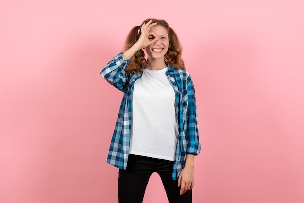 Front view young female in checkered shirt posing on light-pink background youth woman emotions model kid color