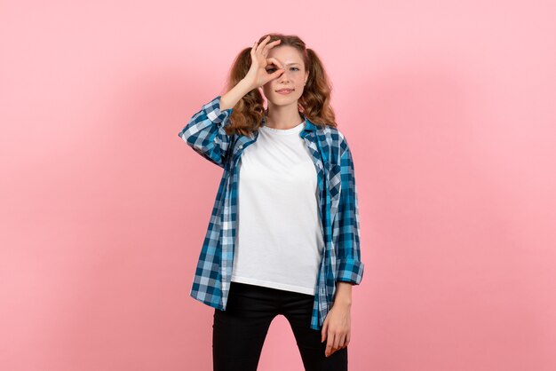 밝은 분홍색 배경에 포즈 체크 무늬 셔츠에 전면보기 젊은 여성 청소년 여자 감정 모델 아이 색상
