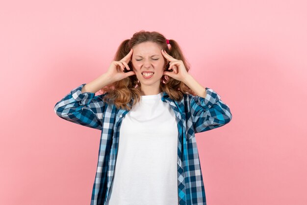 Front view young female in checkered shirt posing on a pink background youth model emotions woman kid girl