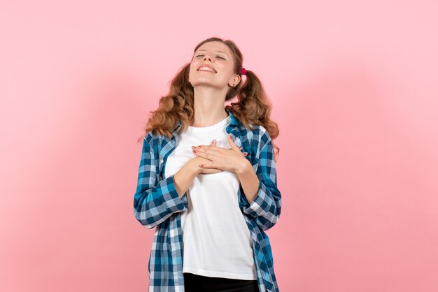 분홍색 배경에 포즈 체크 무늬 셔츠에 전면보기 젊은 여성 청소년 여자 색상 감정 모델 아이