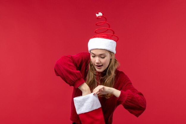 Front view young female checking red christmas sock, red woman holiday