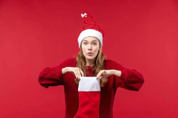 Front view young female checking red christmas sock, red woman holidays