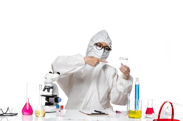 白い床に空のフラスコを保持している特別な防護服を着た若い女性化学者の正面図ラボcovid-chemistryウイルスの健康