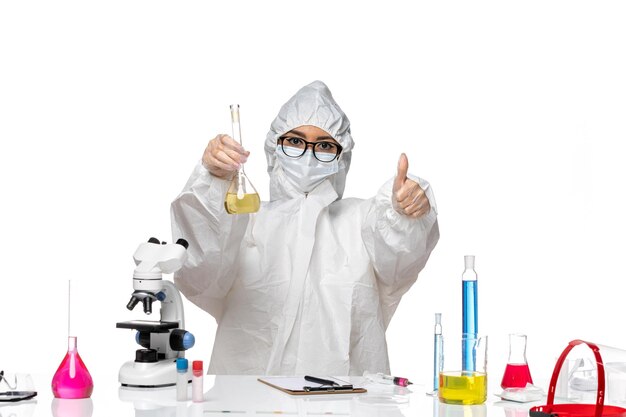 흰색 배경 실험실 covid 화학 바이러스에 플라스크를 들고 특수 보호 복에 전면보기 젊은 여성 화학자