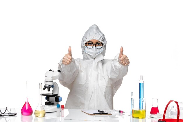 Free photo front view young female chemist in special protective suit just sitting with solutions on a white background virus lab covid chemistry health