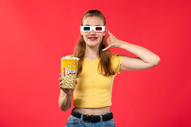 빨간 벽 영화 극장 시네마 여성 재미 영화에 d 선글라스에 팝콘 패키지를 들고 영화관에서 전면보기 젊은 여성