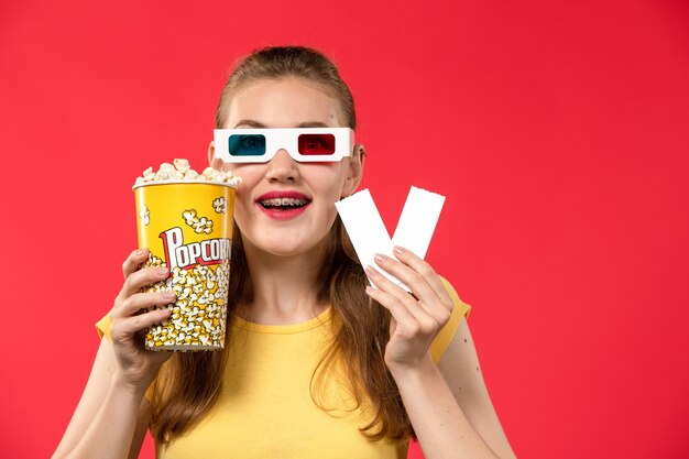 빨간 벽 영화관 영화관 여성 색상에 팝콘과 티켓을 들고 영화관에서 전면보기 젊은 여성