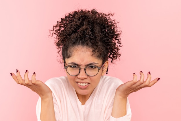 Foto gratuita vista frontale della giovane donna confusa sul rosa