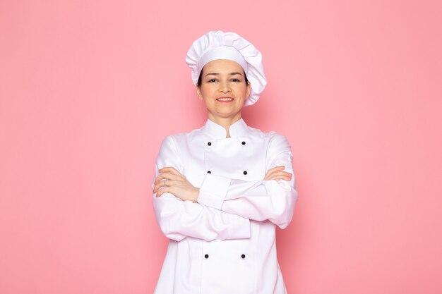 Вид спереди молодая женщина повар в белом костюме повара белая шапка улыбается счастливым