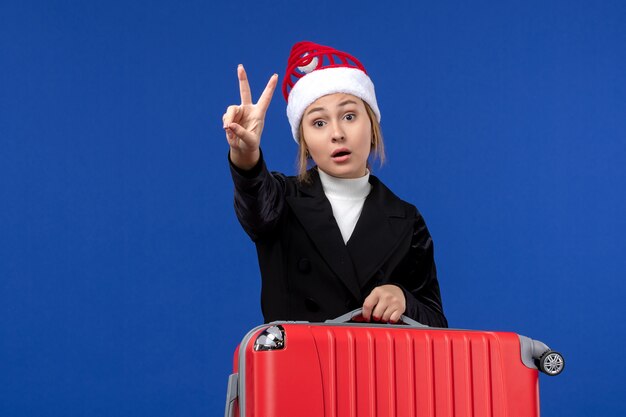 Front view young female counting showing number on blue wall holiday vacation woman