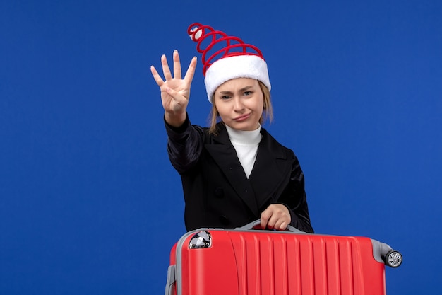 Front view young female counting showing number on blue wall holiday vacation woman