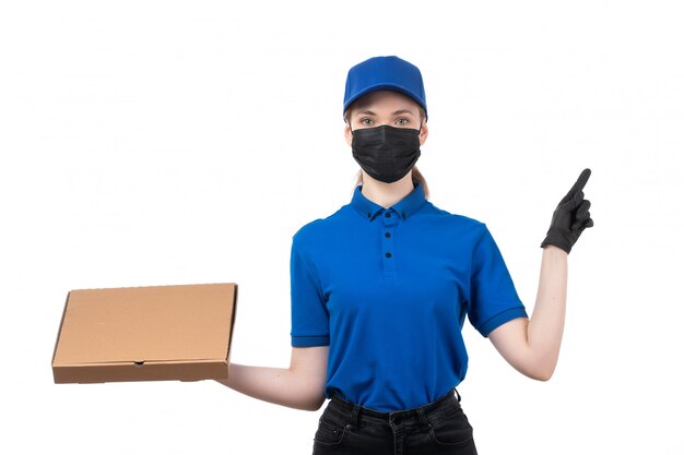 青い制服の黒い手袋とフードデリバリーパッケージを保持している黒いマスクの正面の若い女性の宅配便