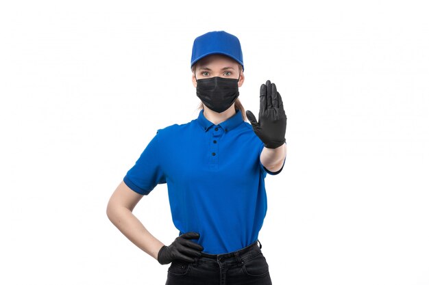 파란색 유니폼 검은 장갑과 정지 신호를 보여주는 검은 마스크에 전면보기 젊은 여성 택배