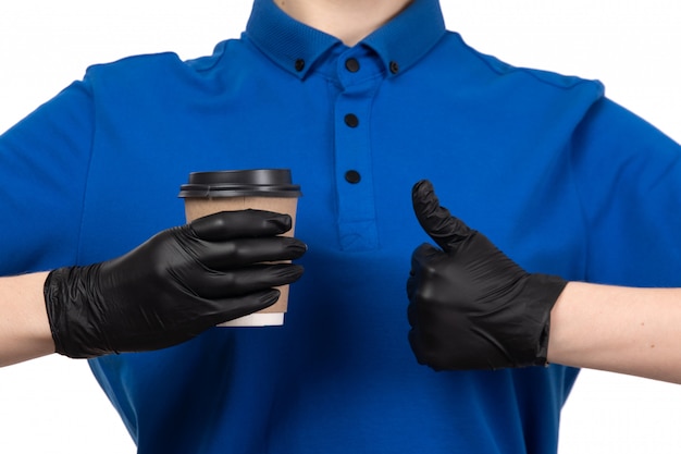 파란색 유니폼 검은 마스크와 장갑 커피 컵을 들고 전면보기 젊은 여성 택배