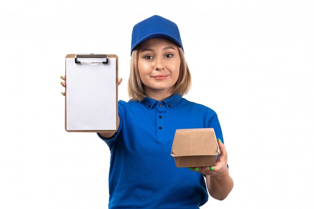 Молодая женщина-курьер в синей форме, держащая пакет для доставки еды и блокнот для подписей, вид спереди