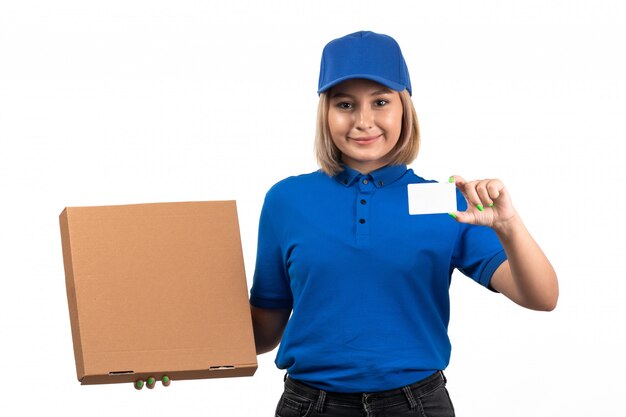 食品配達パッケージと白いカードを保持している青い制服を着た正面若い女性宅配便
