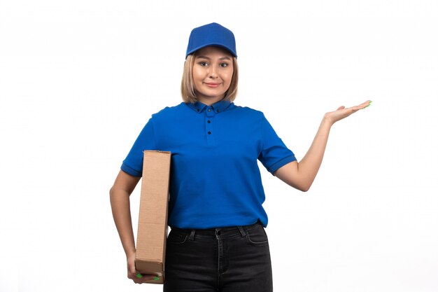 彼女の顔に笑顔で食品配達パッケージを保持している青い制服を着た正面若い女性宅配便