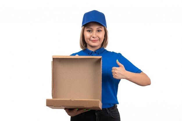 A front view young female courier in blue uniform holding food delivery package