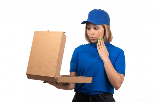 A front view young female courier in blue uniform holding food delivery package