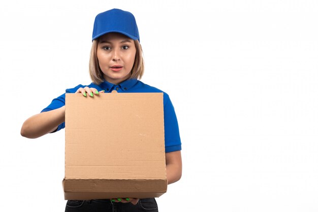 A front view young female courier in blue uniform holding food delivery packages