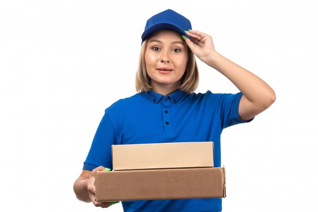 フードデリバリーパッケージを保持している青い制服を着た正面若い女性宅配便