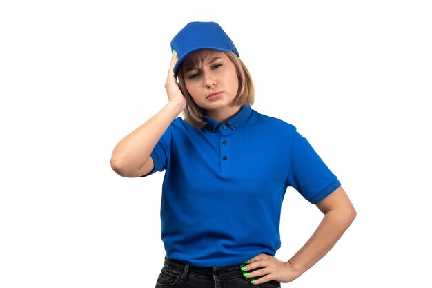 A front view young female courier in blue uniform just having a headache